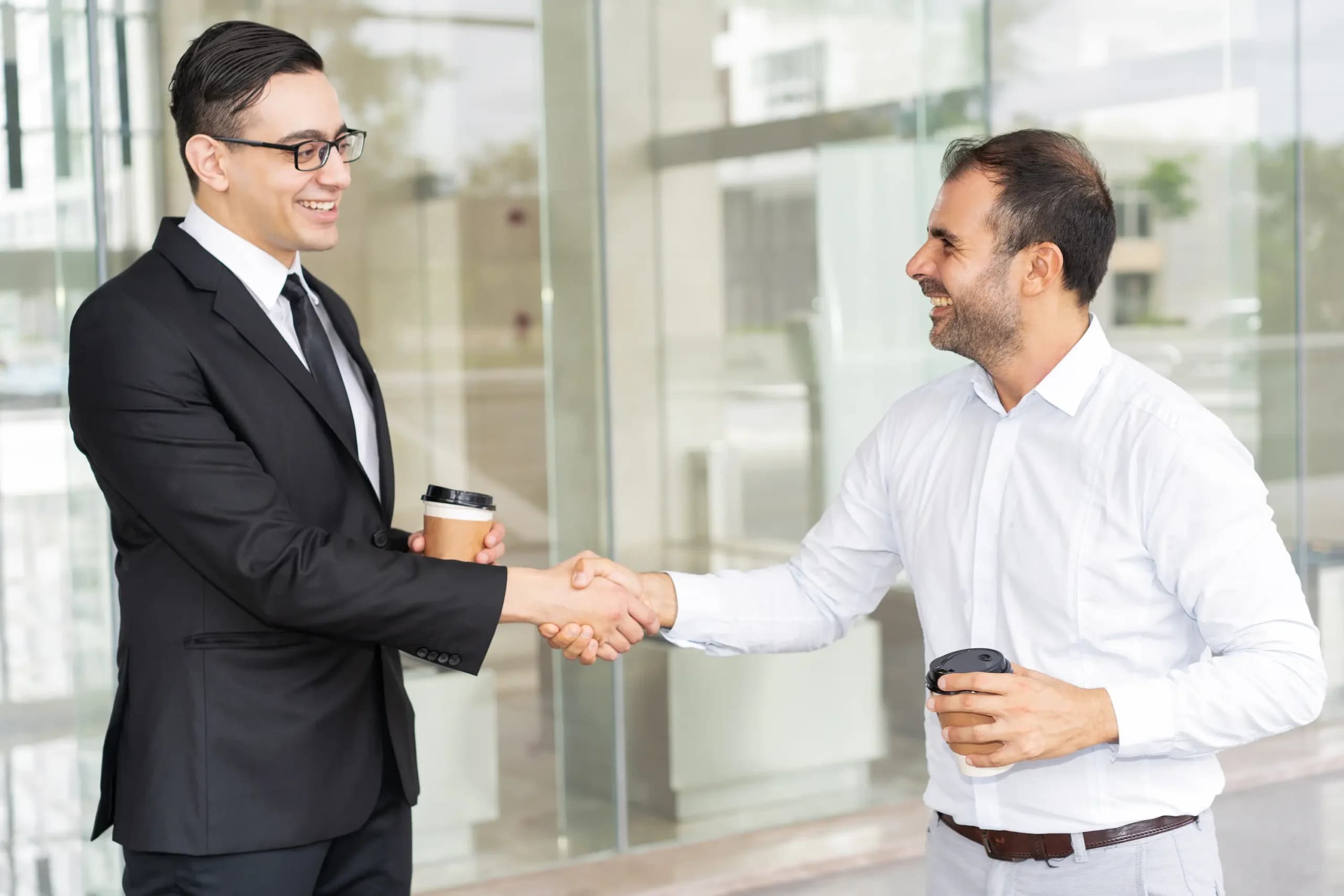 Portrait happy male business partners shaking hands scaled representing Free Zone Company Formation in UAE in the UAE